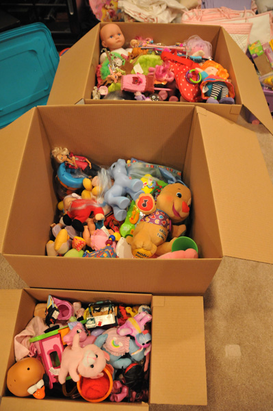 two cardboard boxes full of stuffed animals on a floor