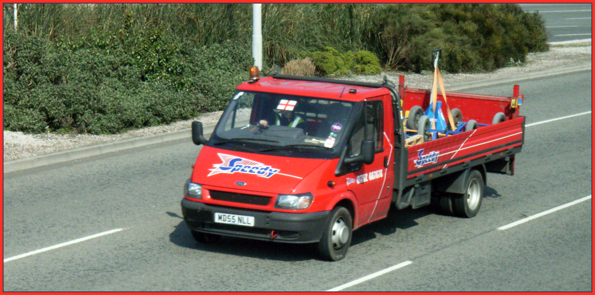 a red truck is driving down the street