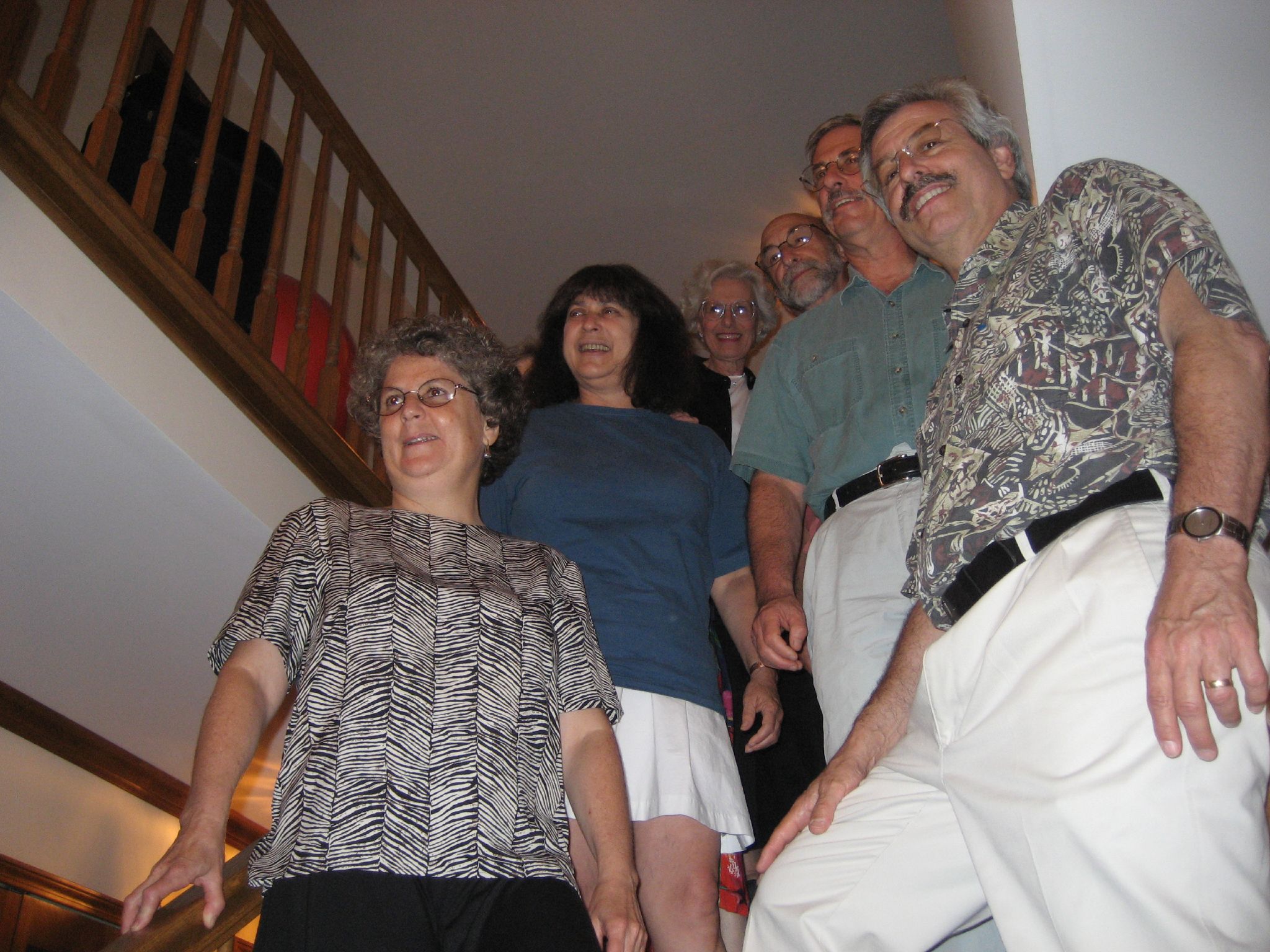 a group of older people standing by the stairs