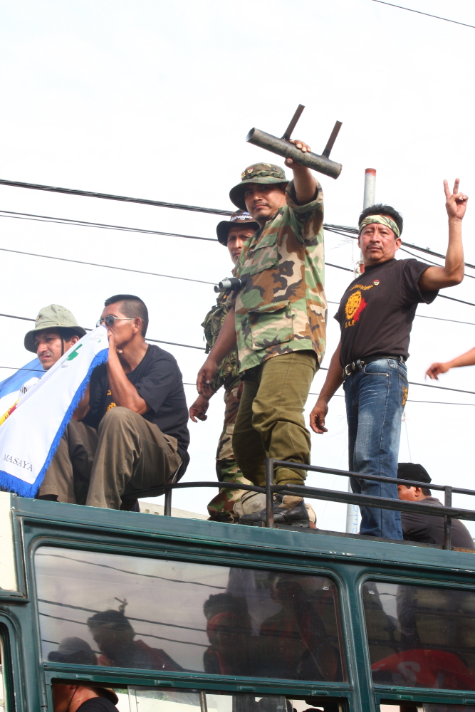 several people sitting in the back of a truck waving to soing