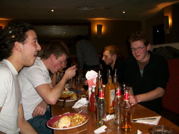 four men eating and drinking at a restaurant