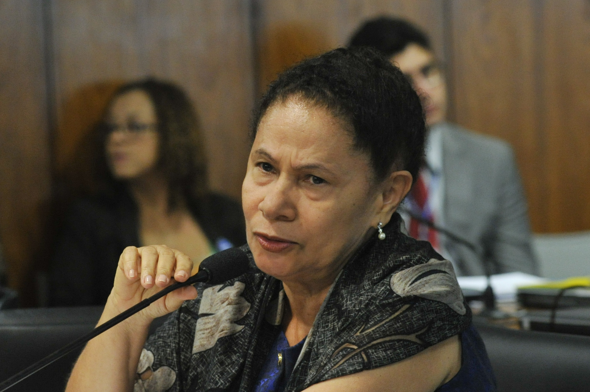 the woman is having her eyes closed while speaking into a microphone