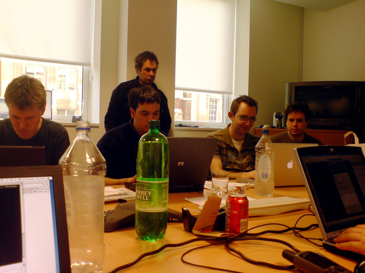 men looking at laptops in front of them on a table