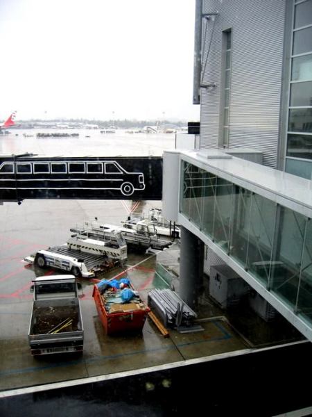 airplanes and vehicles are parked on the tarmac at an airport