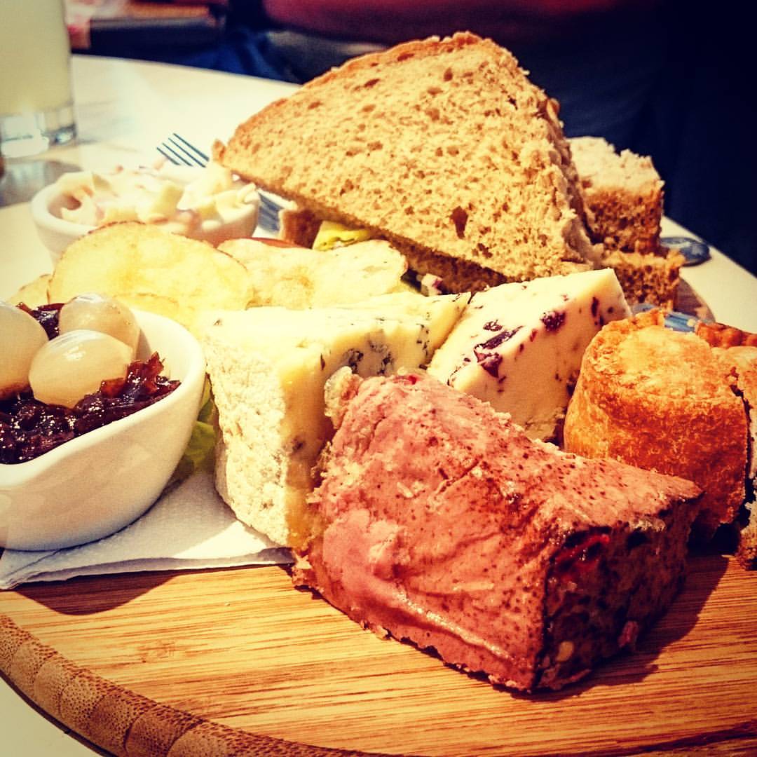 various types of bread are arranged on a wood  board