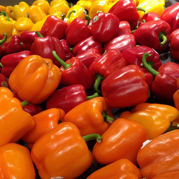 a large pile of red and orange peppers