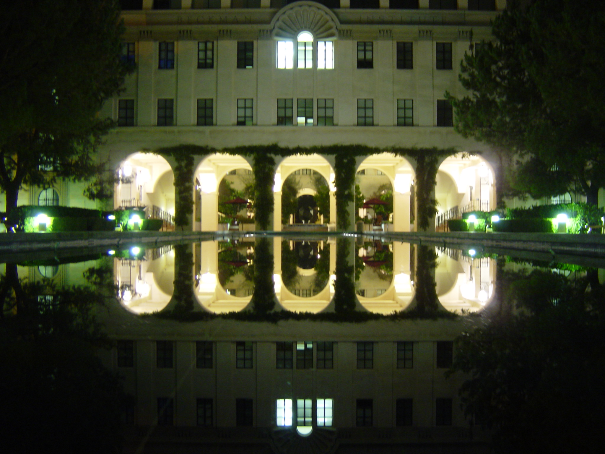 a reflection in the water of a building at night