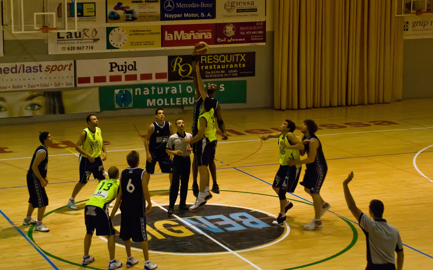 the players and referee on a basketball court