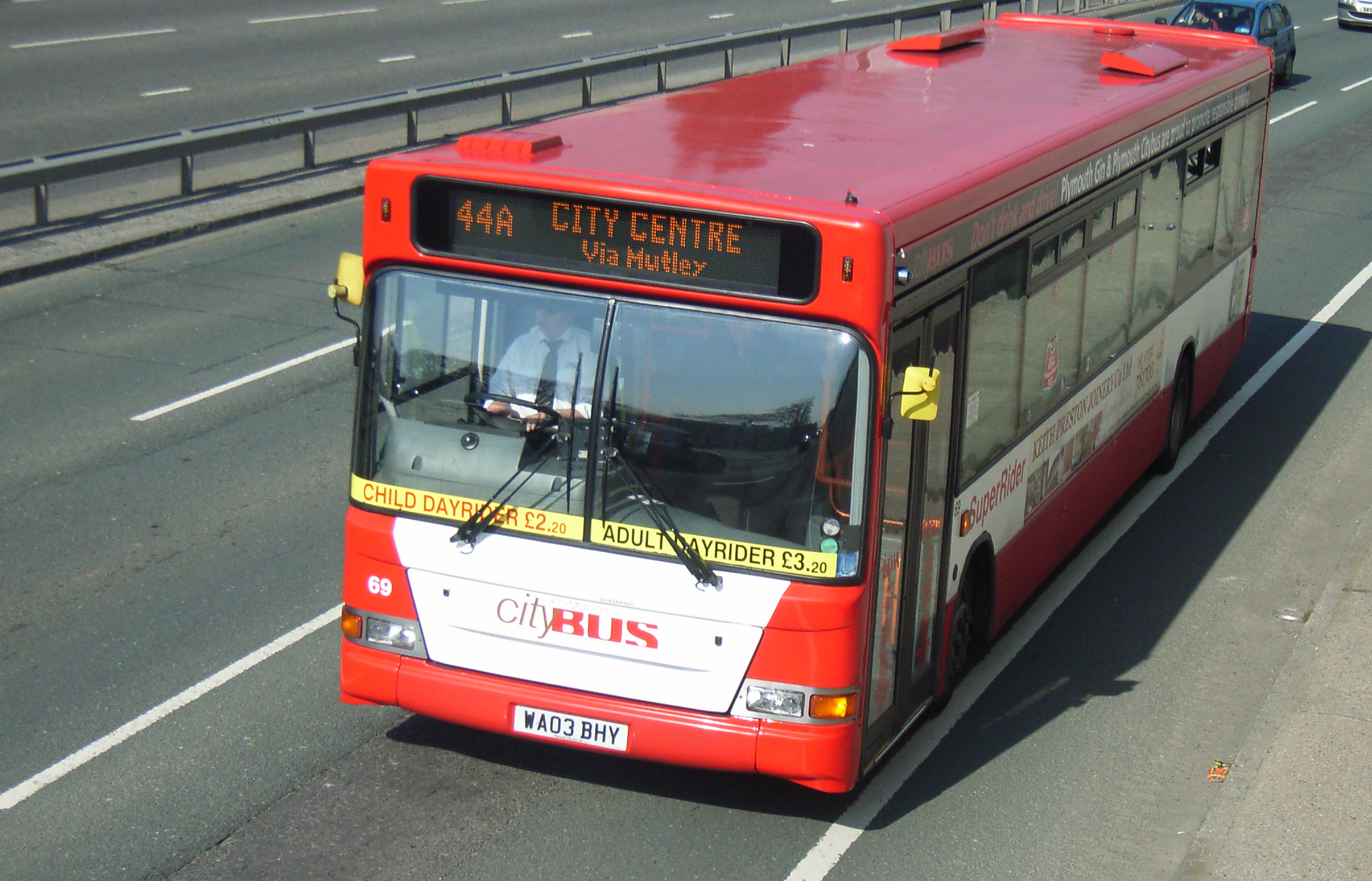 a red and white bus is on a highway