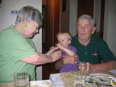 an older man and woman playing with a small child