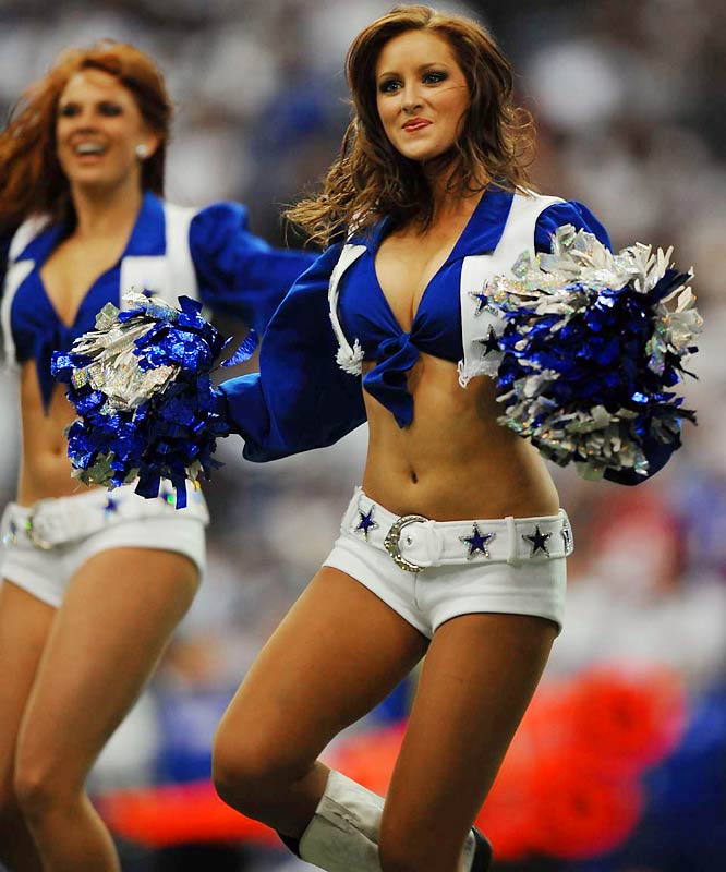 two female cheerleaders in blue uniforms perform for the crowd