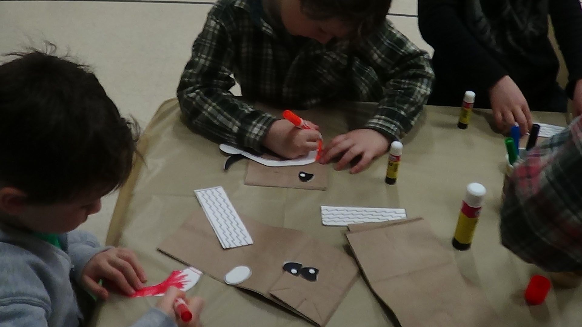 three s are sitting at a table with craft pieces on it