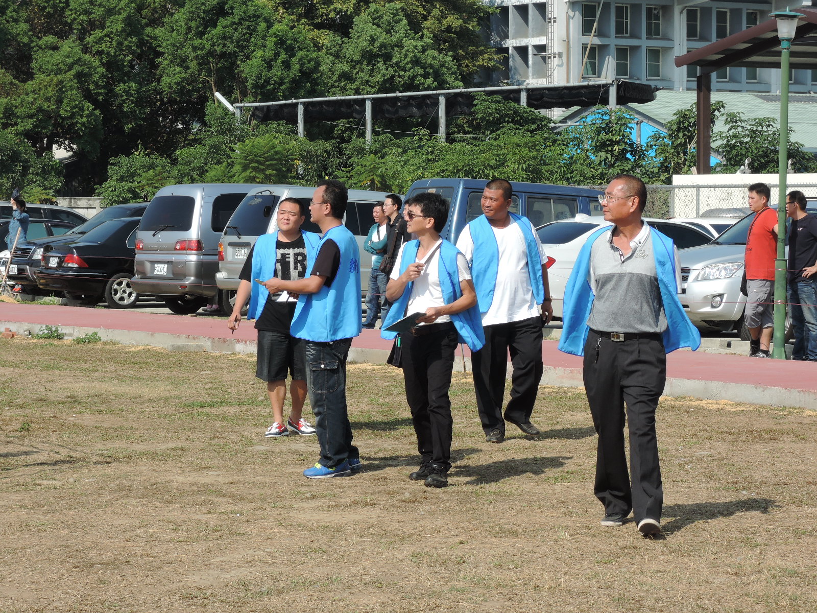 several people are wearing blue vests and talking