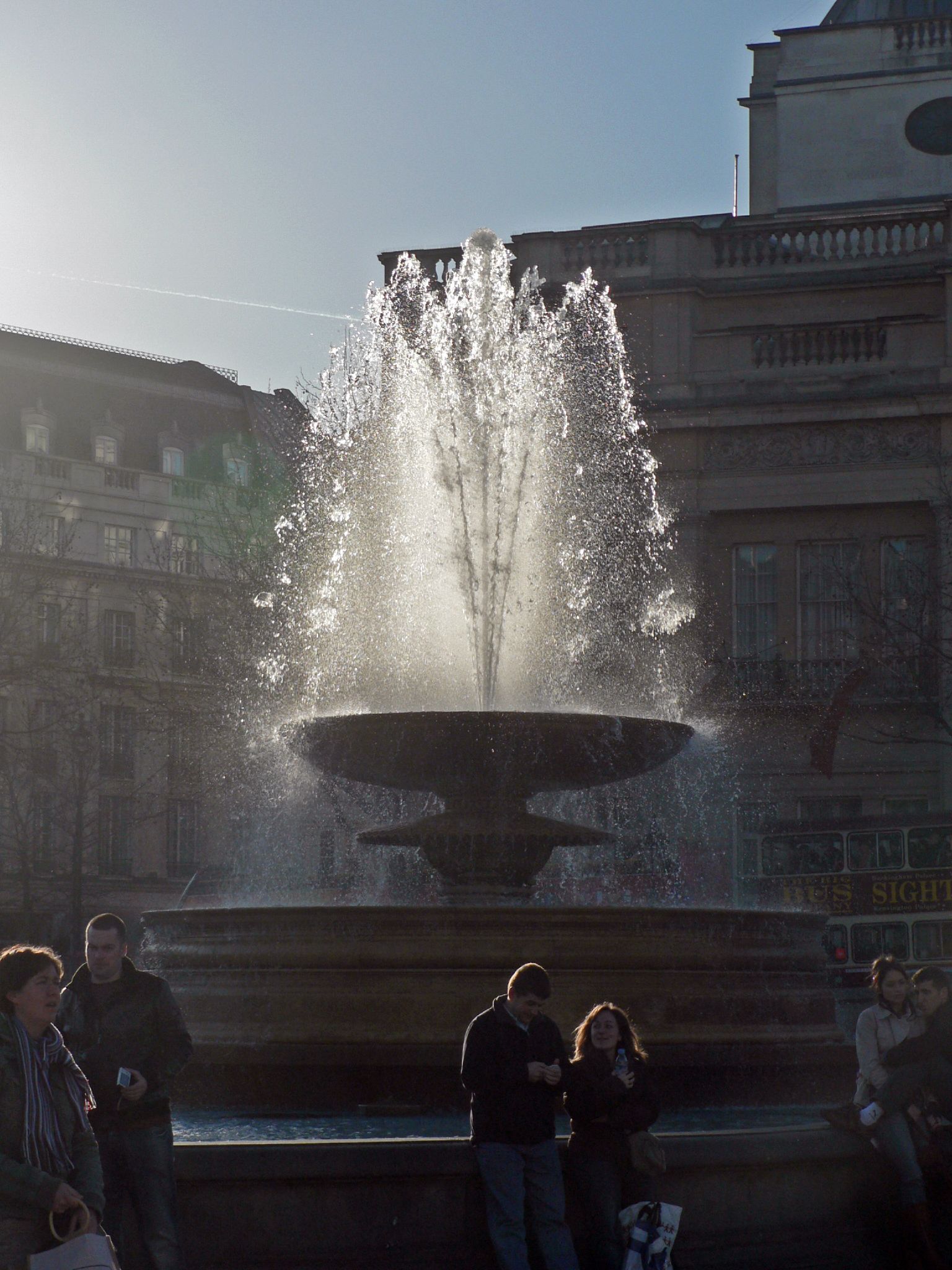 people gather around a large water fountain