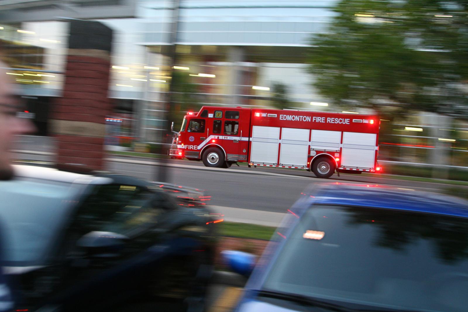 there is a red and white fire truck that is driving down the street