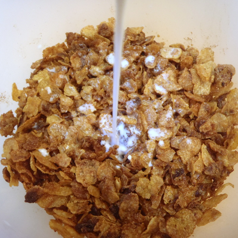 some cereal being poured into a glass bowl