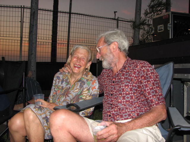 an old couple sitting in chairs next to a gate