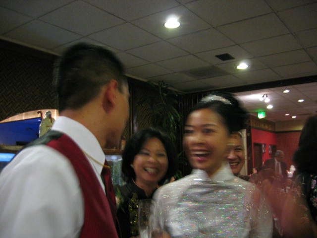 two women laughing while another man watches and gives them laughs