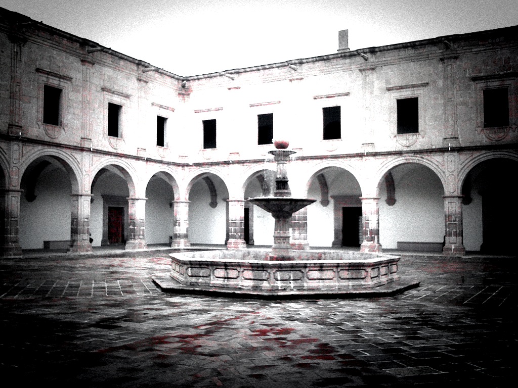 black and white pograph of an old building courtyard with a fountain