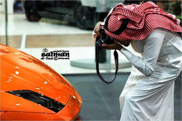 an arab pographer pographs a model car in front of a showroom