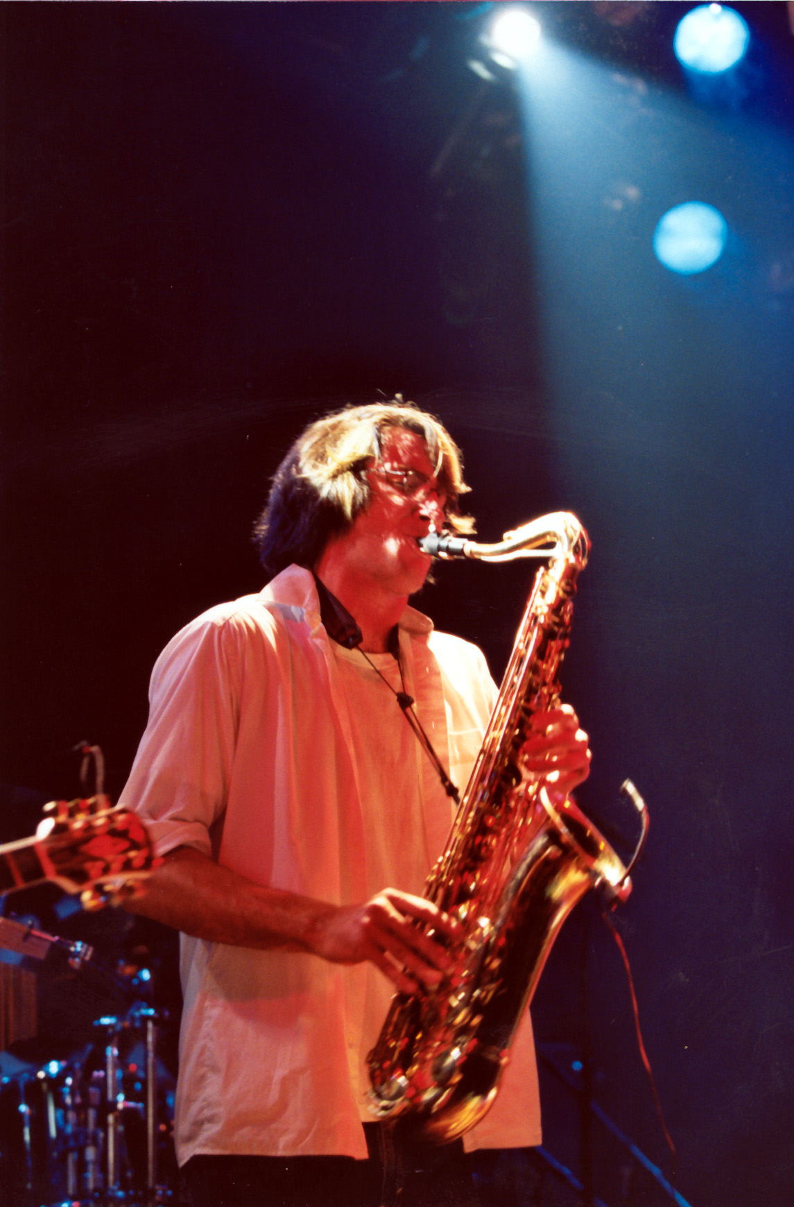 a man standing in front of a keyboard with a saxophone on it