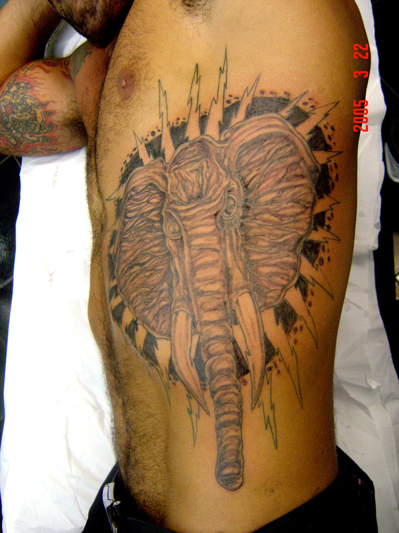 a man with tattoos with an elephant on his thigh