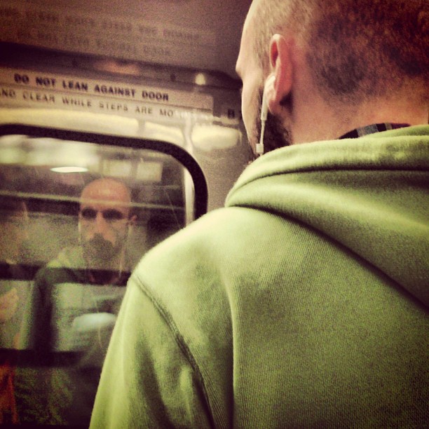 two males with beards are on a public transit train