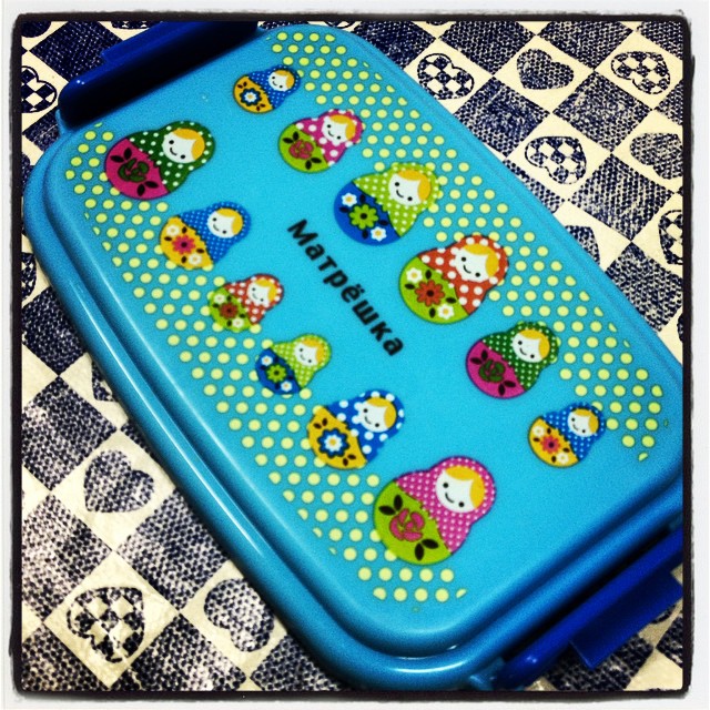 a blue plastic container sitting on a mat covered in polka dot dots