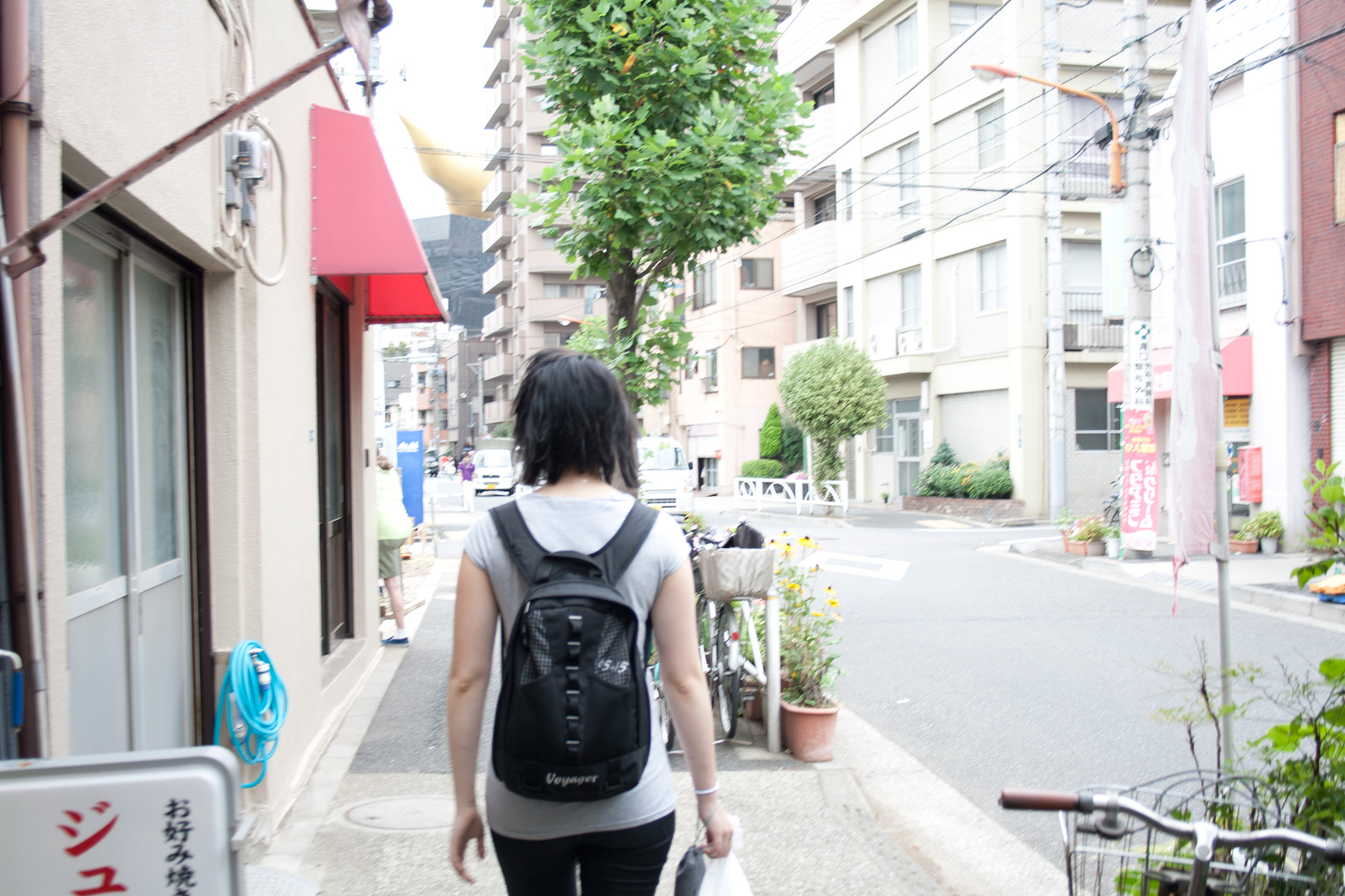 a woman walking down the street with a back pack