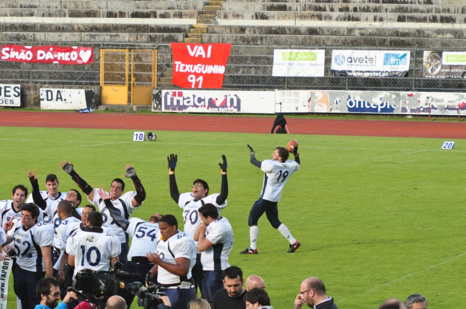 soccer team with arms in the air in front of a crowd