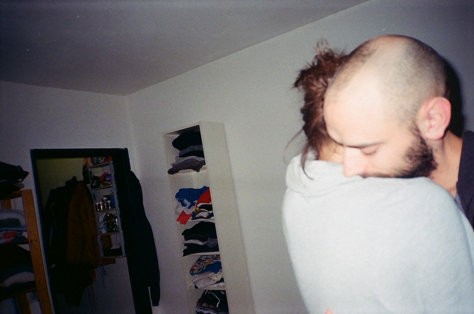 a man in a room with a skateboard rack in the background
