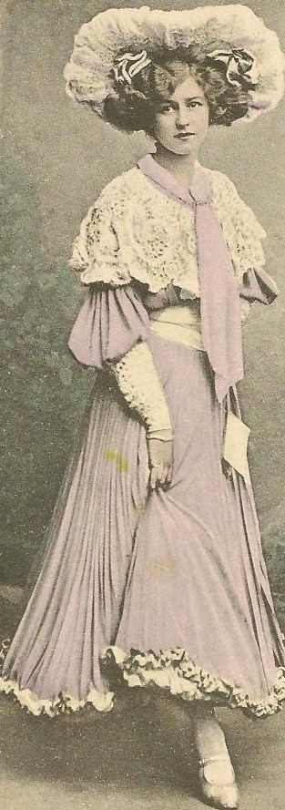 a woman in a dress and hat poses for a portrait