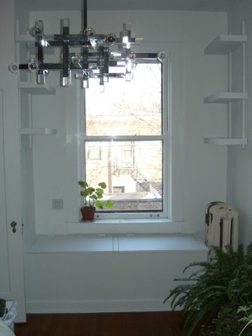 a window with glass and metal bars hanging from it's sides