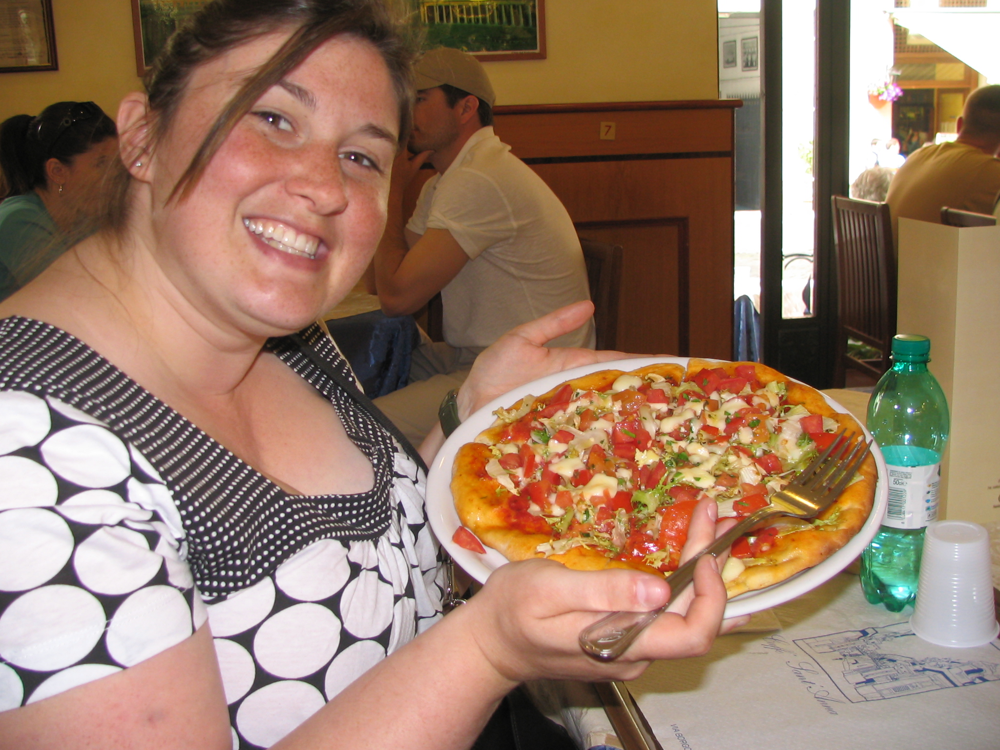 the woman is holding a pizza on a plate