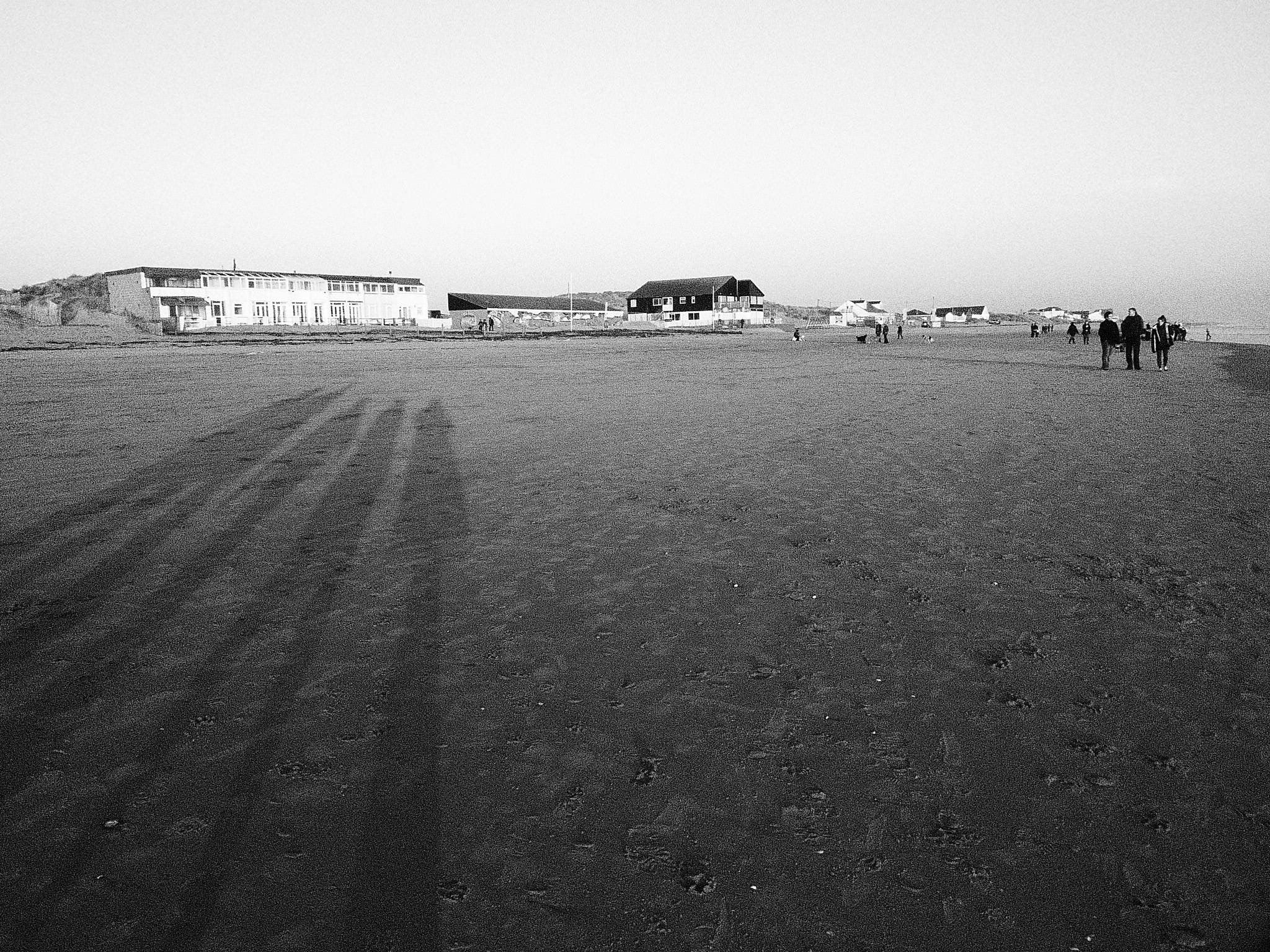 a black and white image with some people on the beach