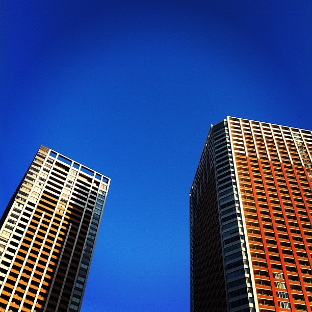 two tall buildings with blue sky in the background