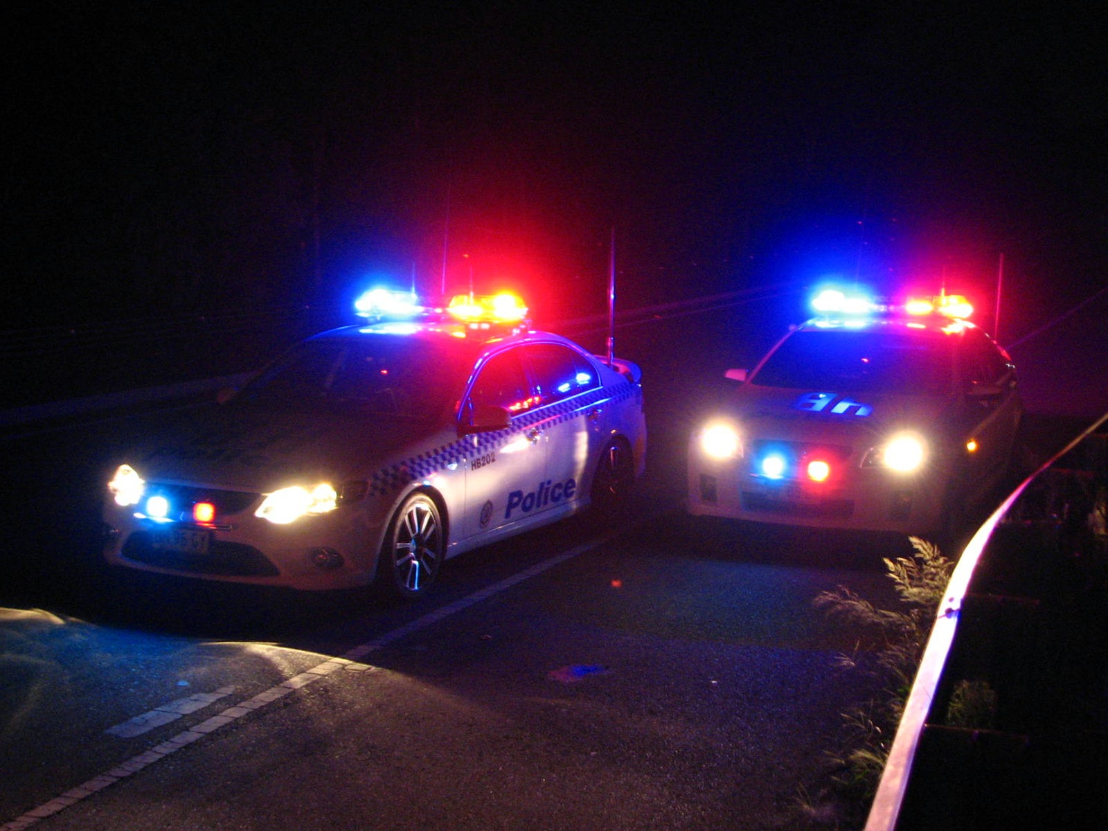 two police cars are parked side by side