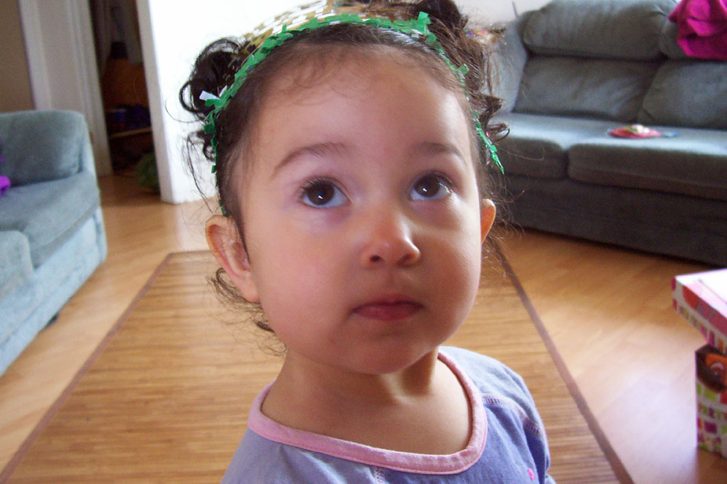 a small child in blue and purple stands in the living room