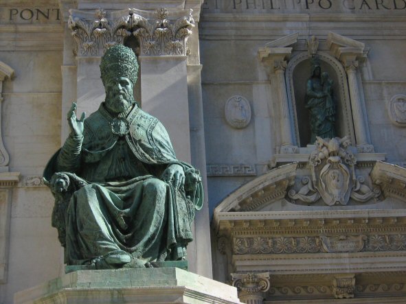 a statue of a man sits in front of a building