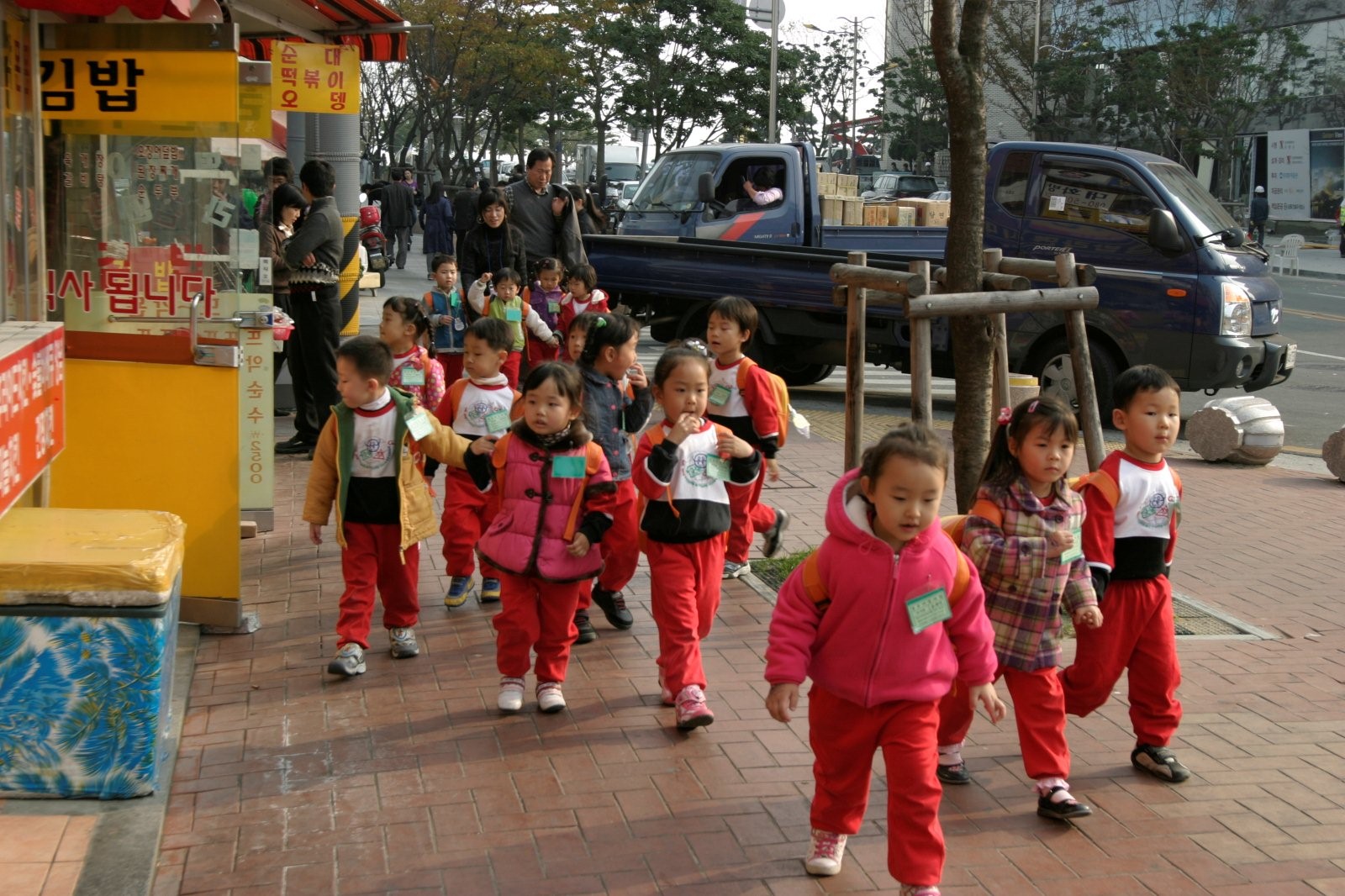 children are in red track pants on the sidewalk