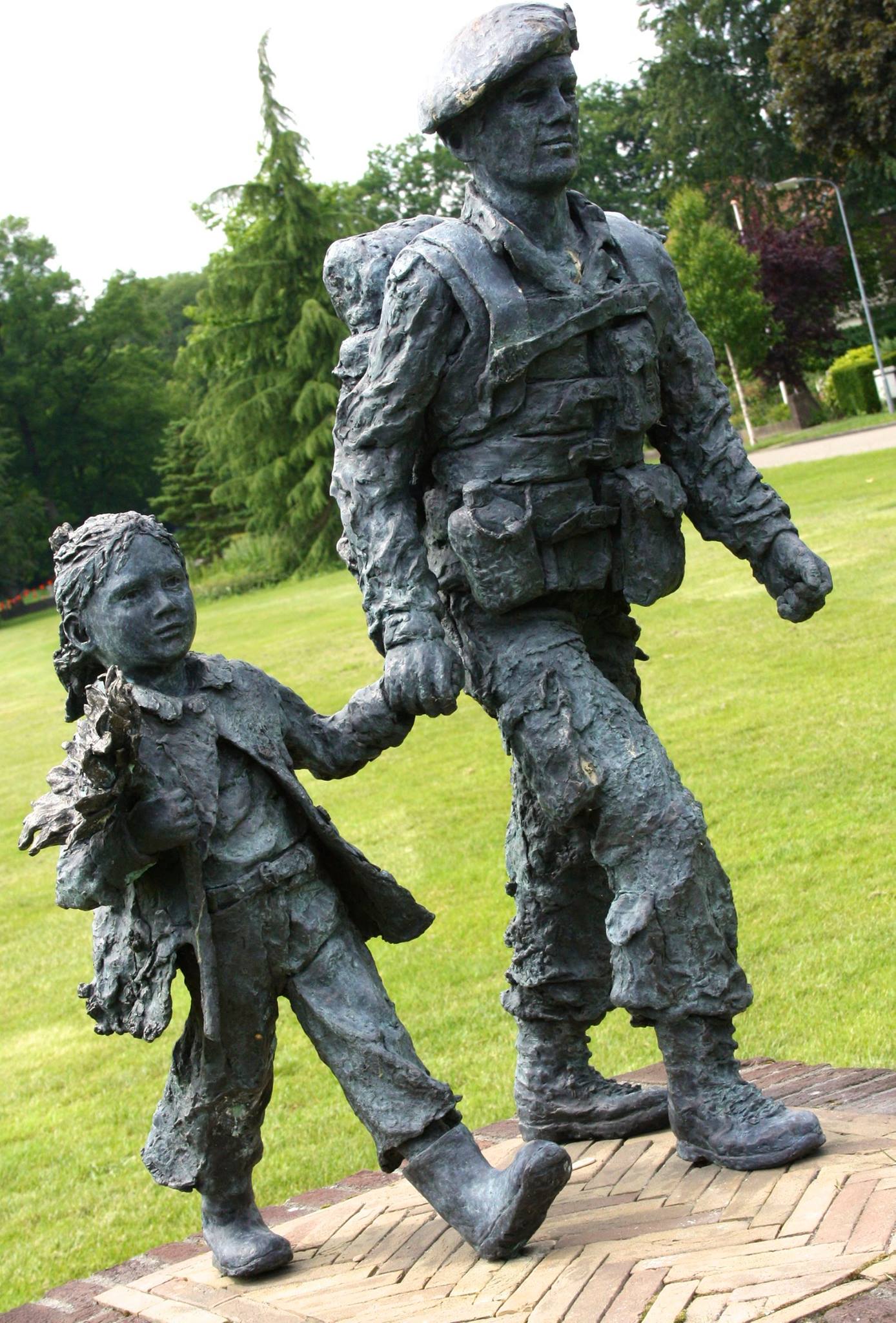 a sculpture of a man holding onto the hand of a child