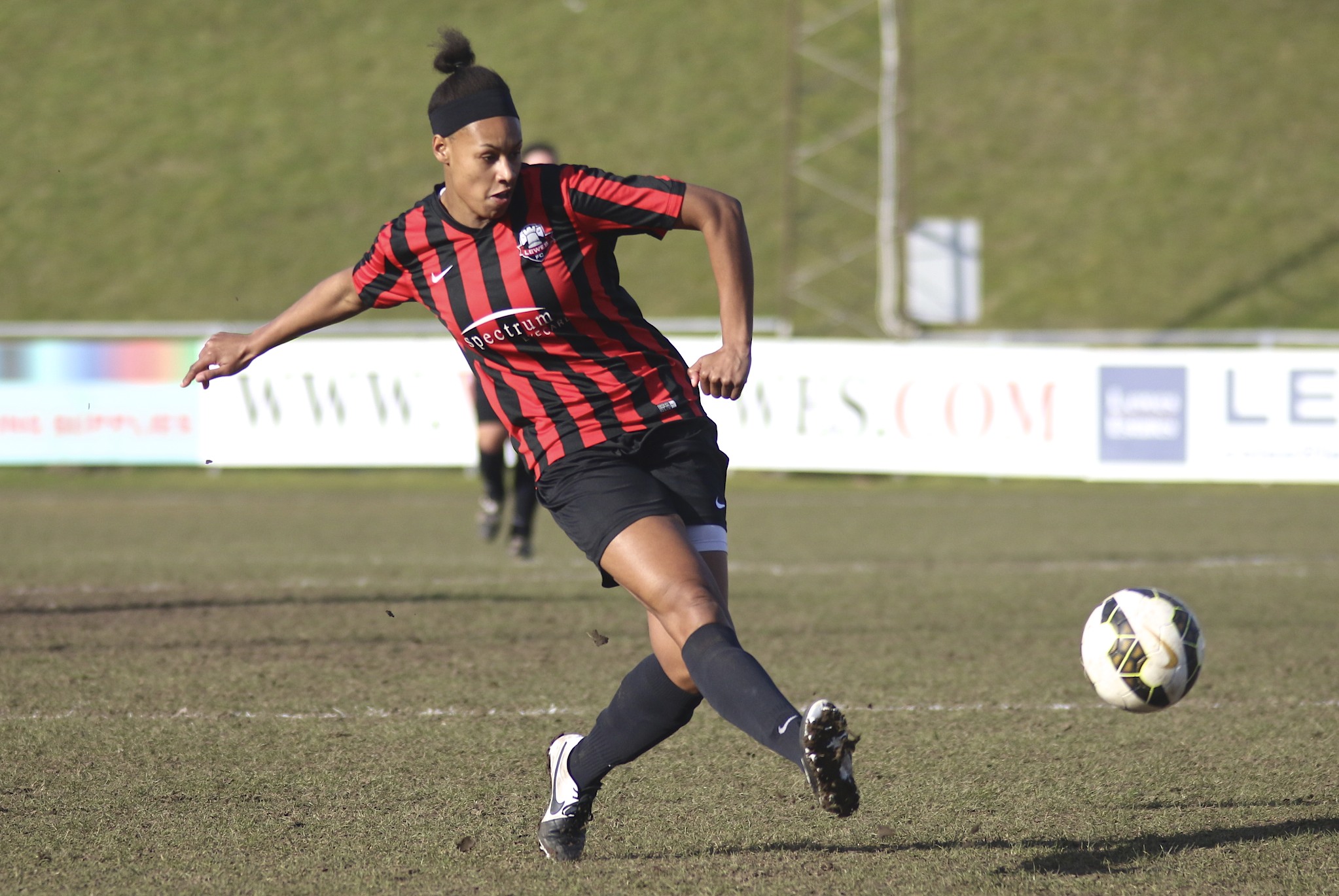 a female soccer player in black and red uniform on the field