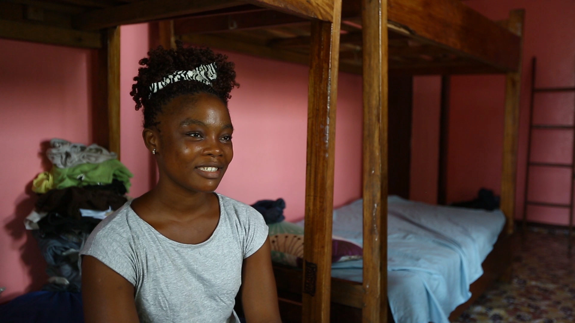 girl in grey shirt in pink room with bunk beds