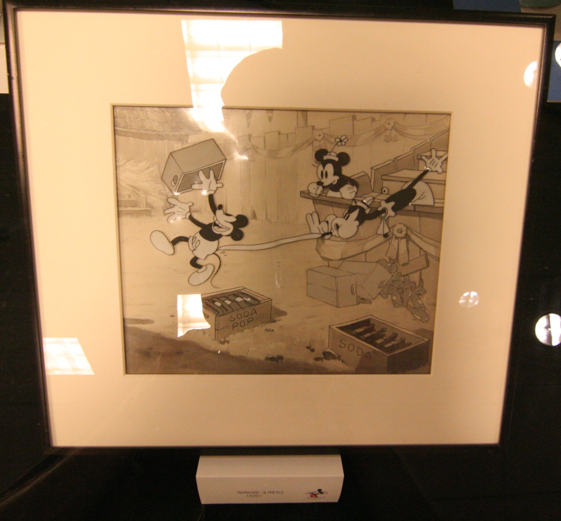 a framed mickey mouse and mickey mouse in a kitchen