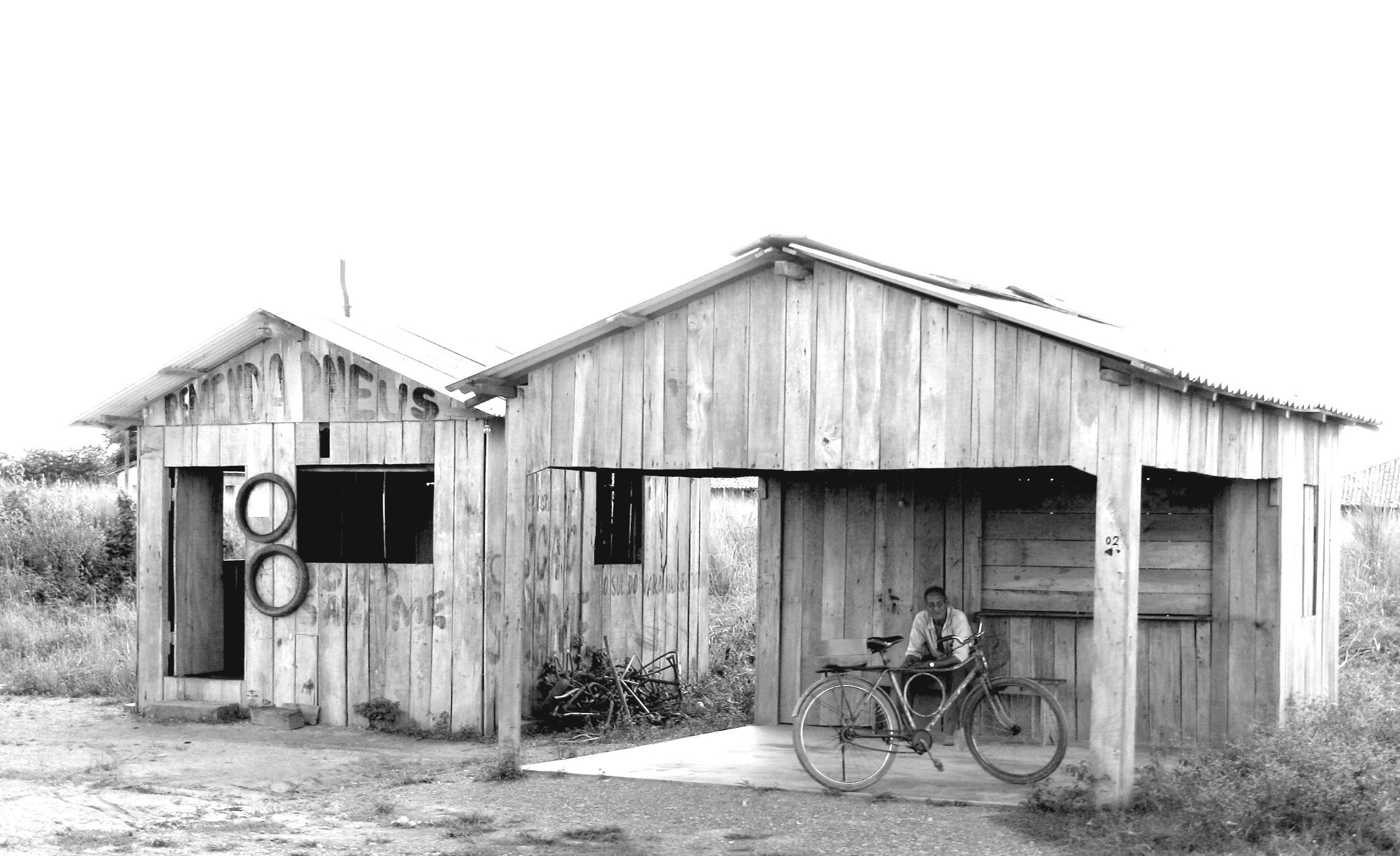 an old barn with a bicycle and a bicycle