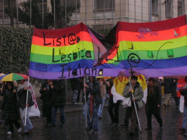 gay people march in the rain carrying rainbow - colored signs