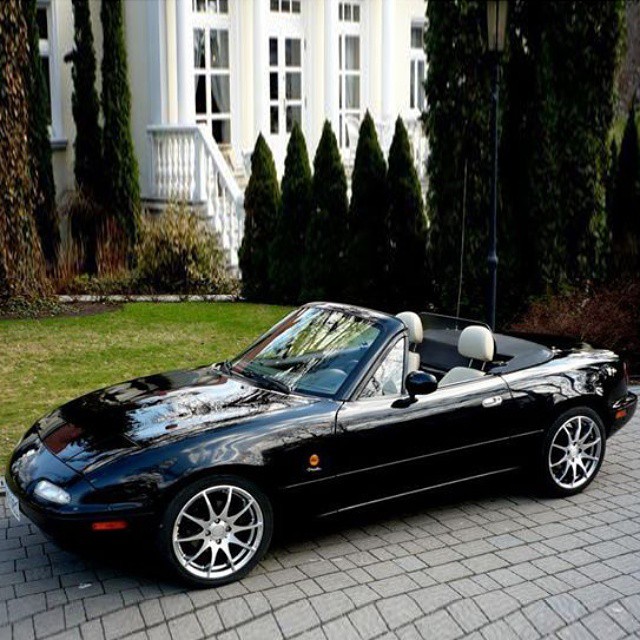 black sports car in driveway near brick walkway with white stairs