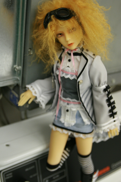 a doll dressed up with sunglasses in front of a microwave