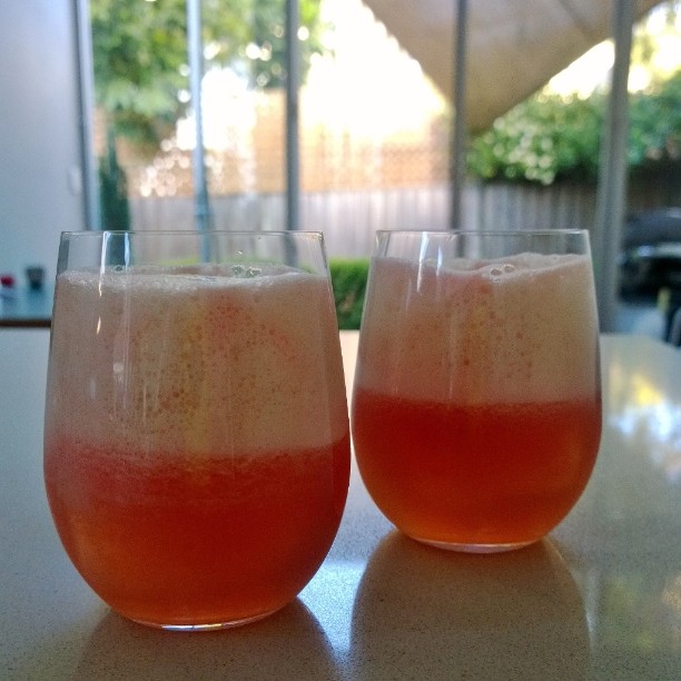 two glasses filled with liquid on a table