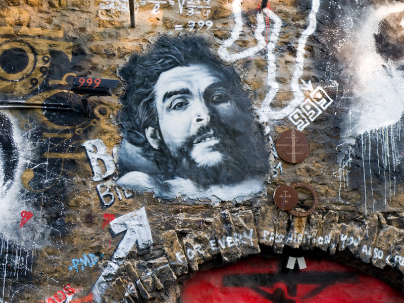 a graffiti covered wall with an image of a man with a beard